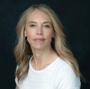Headshot of blond woman with white t-shirt.
